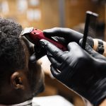 Young man having his hair cut by clipper and comb